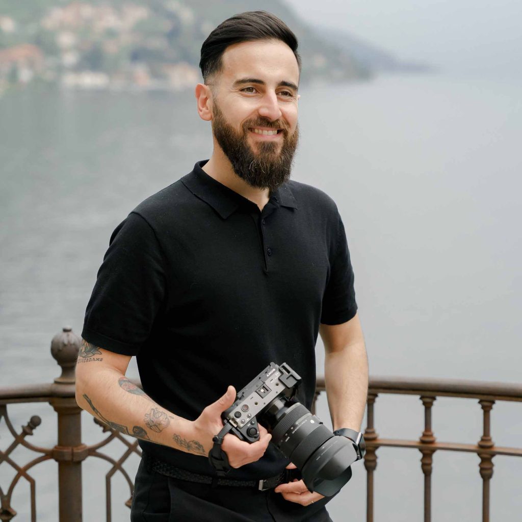Gaetano Di Giacomo, Italian wedding videographer standing by Lake Como with her camera in hand.